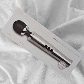 Le Wand Die Cast trådlös wandvibrator på säng