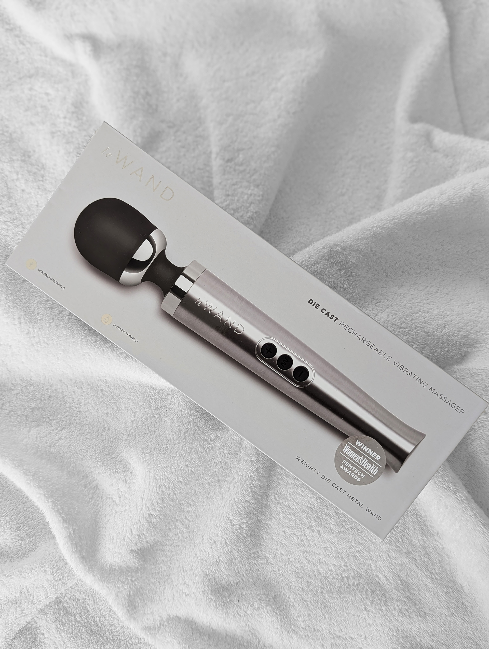 Le Wand Die Cast trådlös wandvibrator på säng