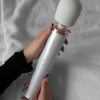 En vacker bild på kvinliga händer som håller i en wand vibrator från le wand