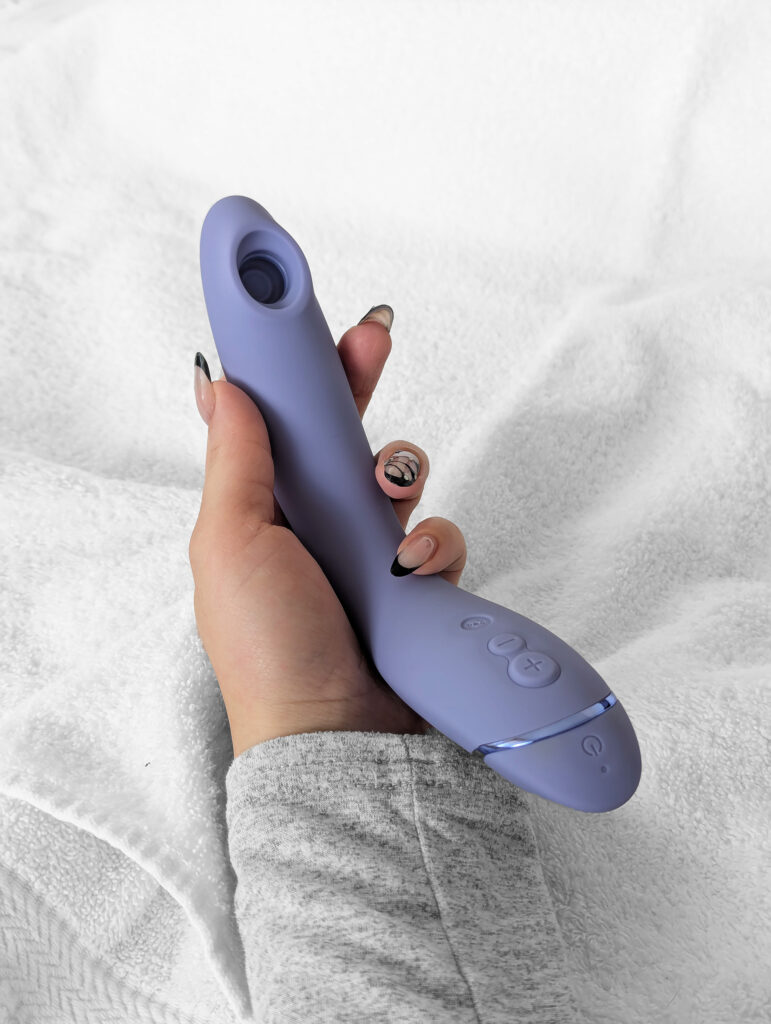 kvinnlig hand håller i womanizer för en recension